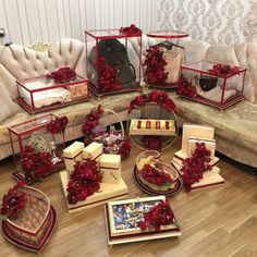 a living room filled with furniture covered in red flowers and boxes on top of them