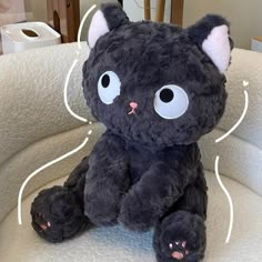 a black cat stuffed animal sitting on top of a chair