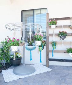 several hanging planters with flowers in them on the outside of a building near a door