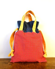 a red and white polka dot bag sitting on top of a wooden table