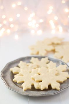 two snowflake cookies sitting on top of a metal plate next to each other