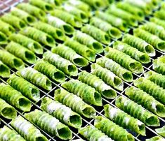 green leaves are drying on a rack in the sun