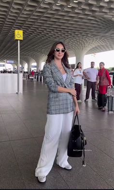 a woman standing in an airport with her hand on her hip