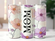 three floral cans with straws in them sitting on a table