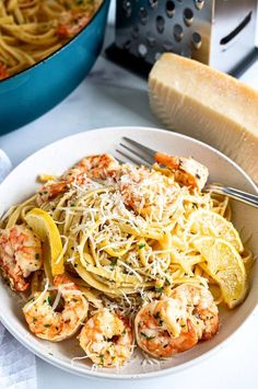 pasta with shrimp, lemon and parmesan cheese in a bowl next to a loaf of bread