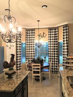 a dining room table and chairs in front of a window with black and white checkered curtains