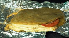 there is a tortilla with meat and vegetables on it in foil wrapper