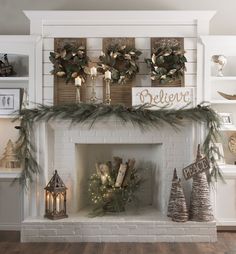 a fireplace decorated for christmas with greenery, candles and wreaths on the mantle