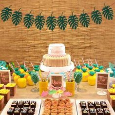 a table topped with lots of desserts next to pineapples and cupcakes