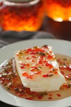 a white plate topped with fish covered in sauce