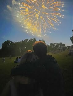 two people are looking at fireworks in the sky