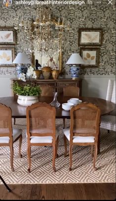 a dining room table with chairs and a chandelier hanging from the wall above it