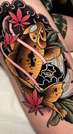 a woman's thigh with an artistic tattoo design on her leg and goldfish in the middle