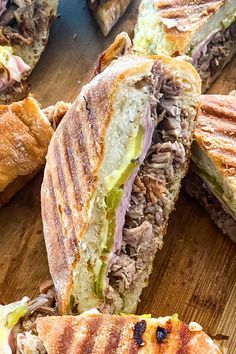 a cut in half sandwich sitting on top of a wooden cutting board