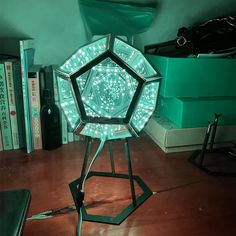 a green light sitting on top of a wooden table next to a book shelf with books