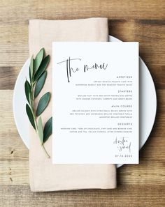 a white plate topped with a menu and greenery