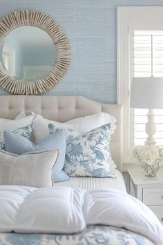 a bedroom with blue and white decor on the walls, bed linens, and pillows