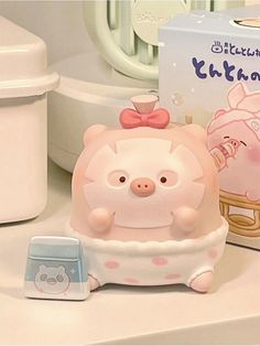 a pig toy sitting on top of a counter next to a box of toothpaste