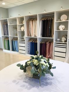 a vase with flowers sitting on top of a table in front of some closets