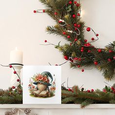 a christmas mantle decorated with pine cones, holly and red berries next to a lit candle