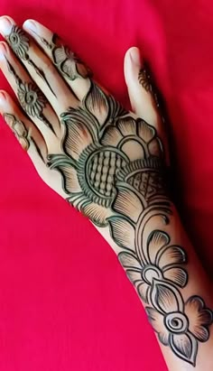 a woman's hand with henna tattoos on it