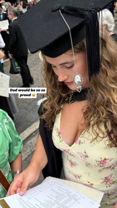 a woman wearing a graduation cap and gown holding a piece of paper with the words dad would be so proud