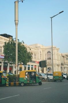 a street scene with cars and trucks driving down the road in front of a large white building