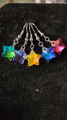 These are earrings. Each set has a small star about the size of a dime. They are on stainless steel jump rings and fish hook earring backs. They will also come with clear gel stops. The beads are a multi colored each one changes color based on the ways it shimmers in the light. Blue Star Charm Earrings For Party, Colorful Star-shaped Jewelry For Gifts, Handmade Rainbow Star Jewelry, Ocean-inspired Blue Jewelry With Star Charm, Multicolor Star Earrings, Star-shaped Crystal Earrings For Gifts, Cheap Multicolor Star-shaped Earrings, Rainbow Star-shaped Jewelry With Star Charm, Clear Gel