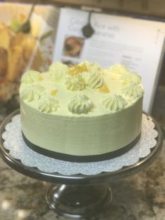 a cake with white frosting sitting on top of a table next to a menu