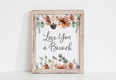 a wooden frame with flowers and the words love you a brunch