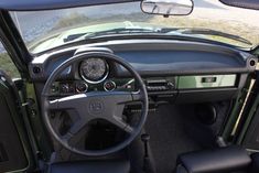 the interior of an old car with dashboard and steering wheel