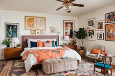 a bedroom decorated in orange and blue with pictures on the wall