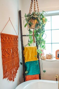 a bathroom with a plant hanging on the wall next to a bathtub and sink