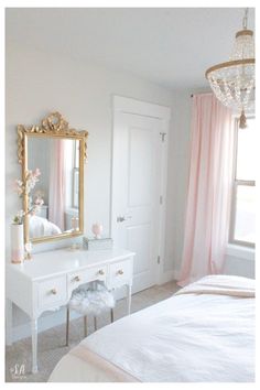 a bedroom with a white dresser and pink drapes on the windowsill, chandelier, and mirror