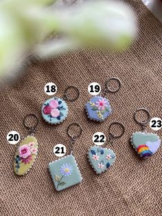 the keychains are decorated with flowers and heart shapes, which have numbers on them