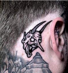 a man with a goat head tattoo on his ear