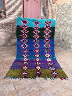 a multicolored rug on the floor in front of a door