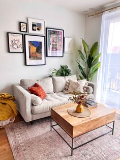 a living room with pictures on the wall and a couch in front of a coffee table