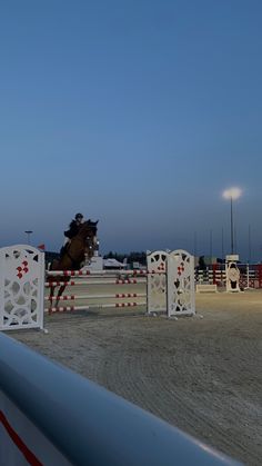 a person riding a horse jumping over an obstacle