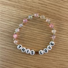 a bracelet with the words this is love written on it and beaded in white letters