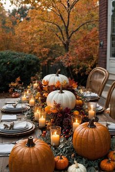 a table with pumpkins and candles on it