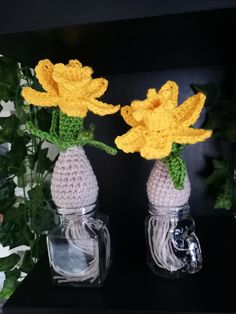 two crocheted vases with yellow flowers in them