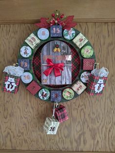 a christmas wreath hanging on the side of a wooden door with tags attached to it