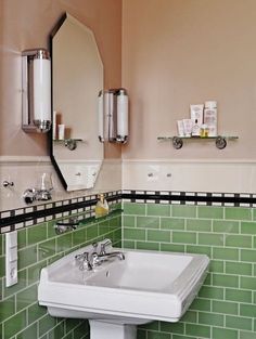 a bathroom with green tiles on the walls and white sink in the center, along with two mirrors above it