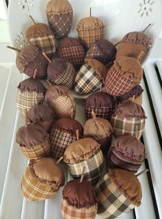 a white bowl filled with lots of brown cupcakes on top of a table