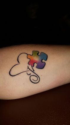 a colorful piece of puzzle tattoo on the arm