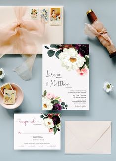 the wedding stationery is laid out with flowers