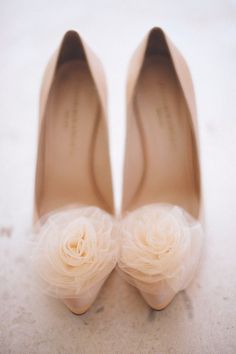 a pair of white shoes with flowers on the toe and heels that have been made to look like they are being worn by someone