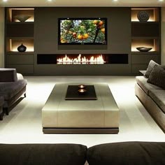 a living room with couches and a flat screen tv on the wall in front of a fireplace