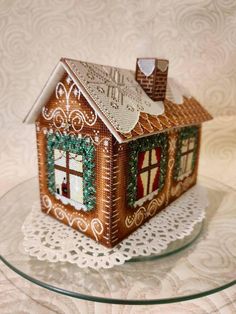 a gingerbread house is sitting on a glass plate